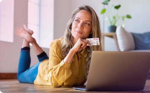Frau hält eine Kreditkarte und lächelt