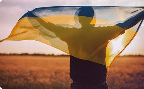 Mann haltet ukrainische Flagge