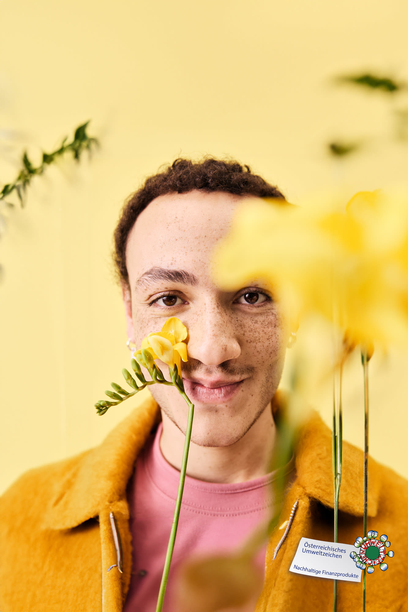 Mann mit Blume im Gesicht und Umweltzeichen – BKS Natur & Zukunft Konto: ökologisch und zertifiziert.