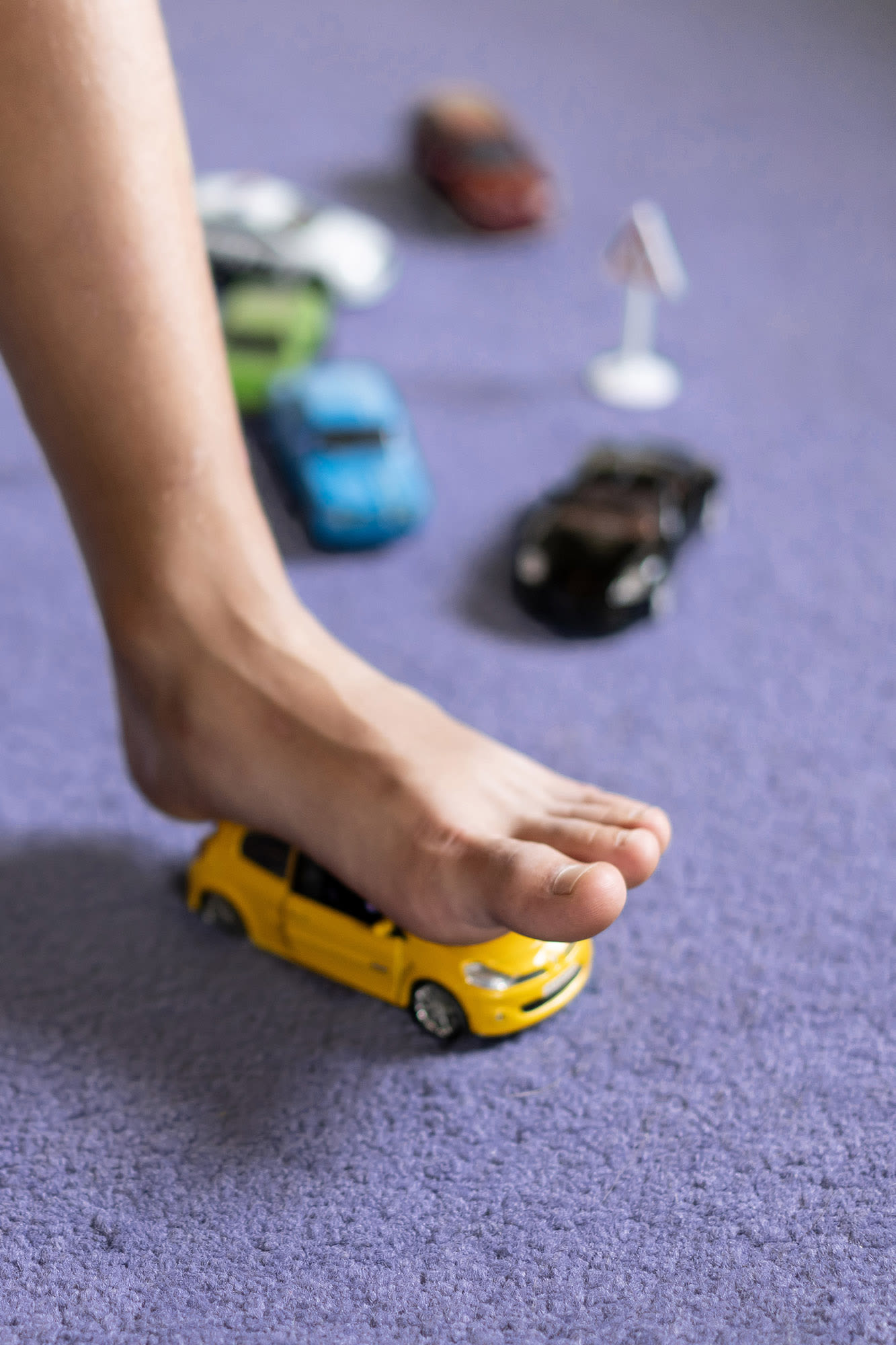 Barfuß auf Spielzeugauto mit Warnschild – BKS All-Risk schützt vor kleinen Unfällen Barfuß auf Spielzeugauto mit Warnschild – BKS All-Risk schützt vor kleinen Unfällen