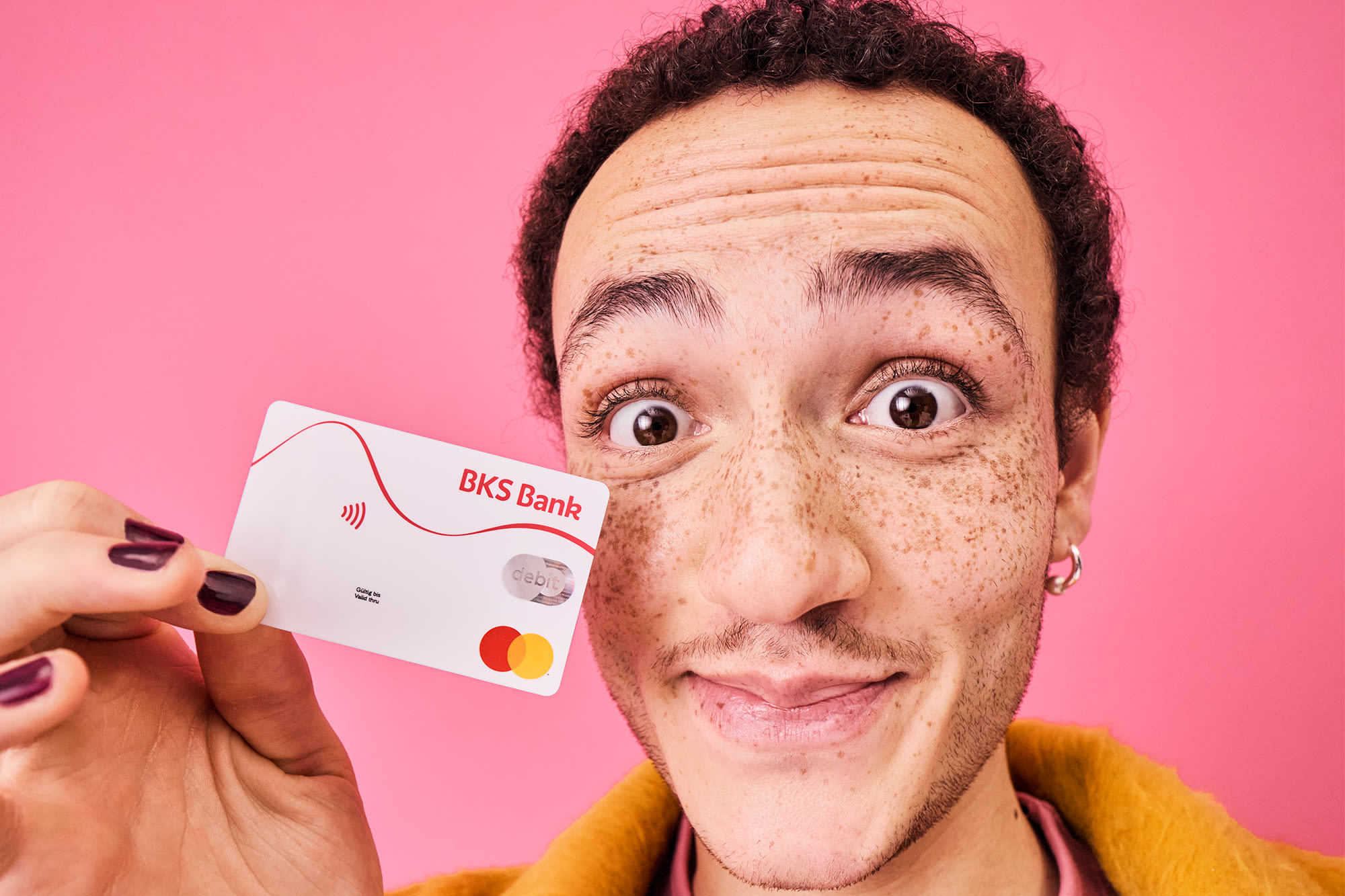 Mann mit BKS Debitkarte - Cashback Aktion