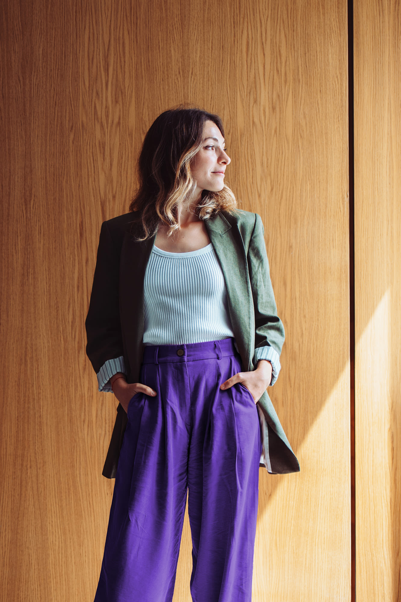 Junge Frau schaut aus Fenster raus – Versichern und Vorsorgen mit der BKS Bank