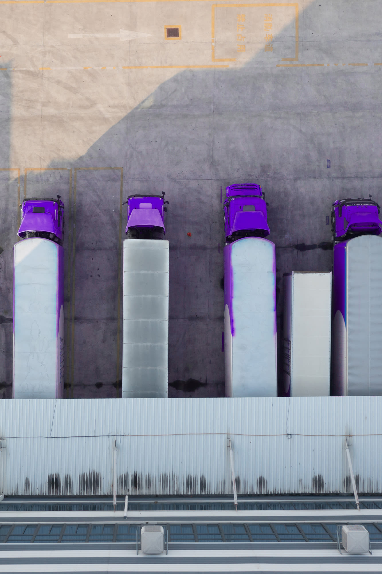 LKW-Flotte an Verladerampe – BKS Bank Exportgarantien stärken internationale Geschäfte.