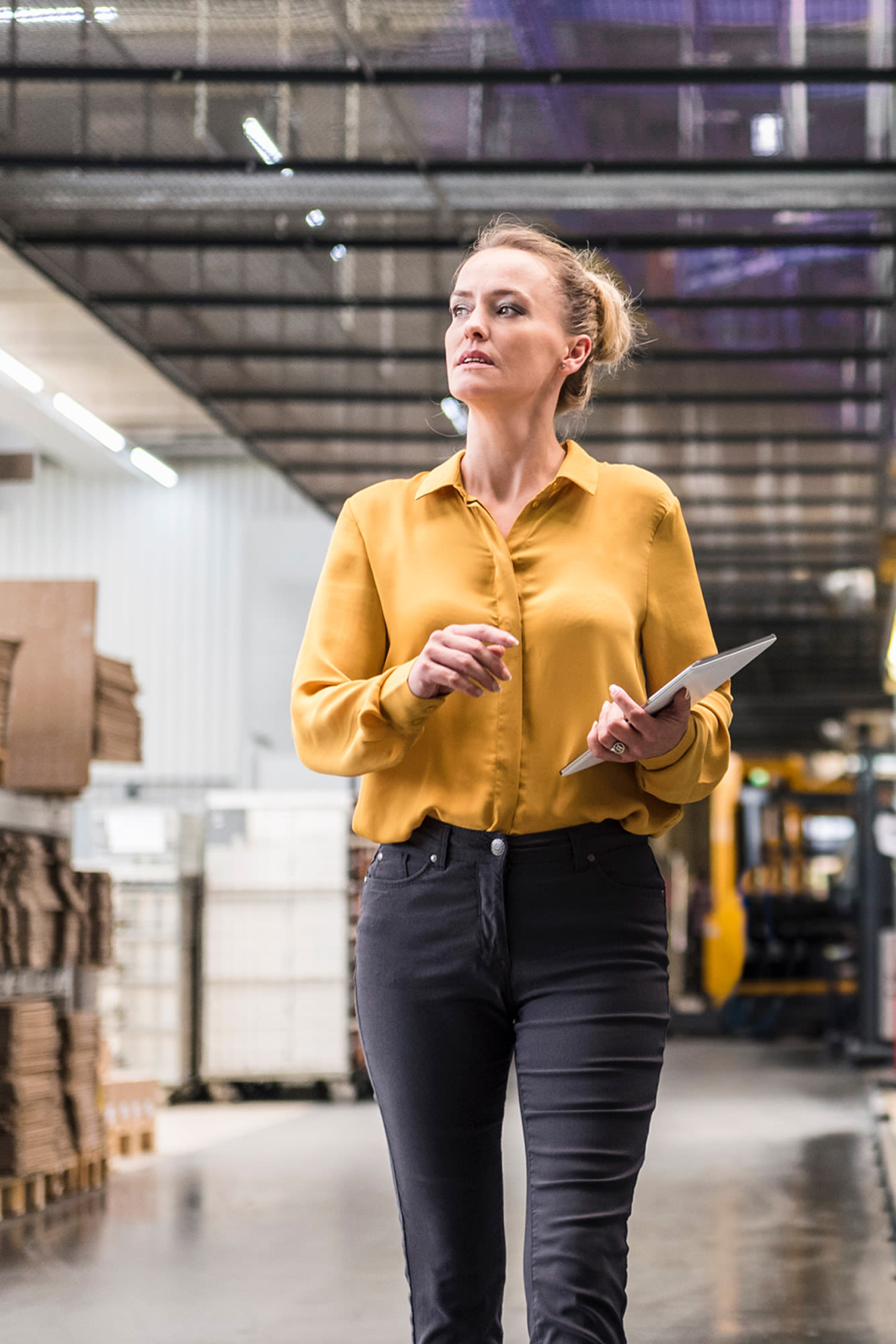 Frau mit Tablet im modernen Lager – Investitionsfinanzierung für Unternehmen mit der BKS Bank.